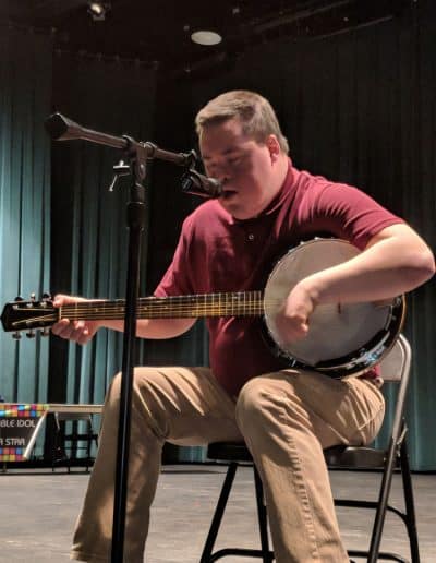 A man plays banjo in the talent show