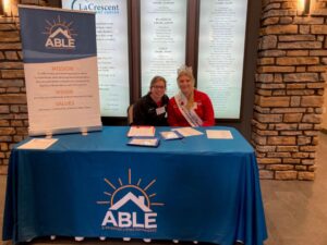 ABLE newsletter June 2024 - 2 people sitting at a table providing information on ABLE